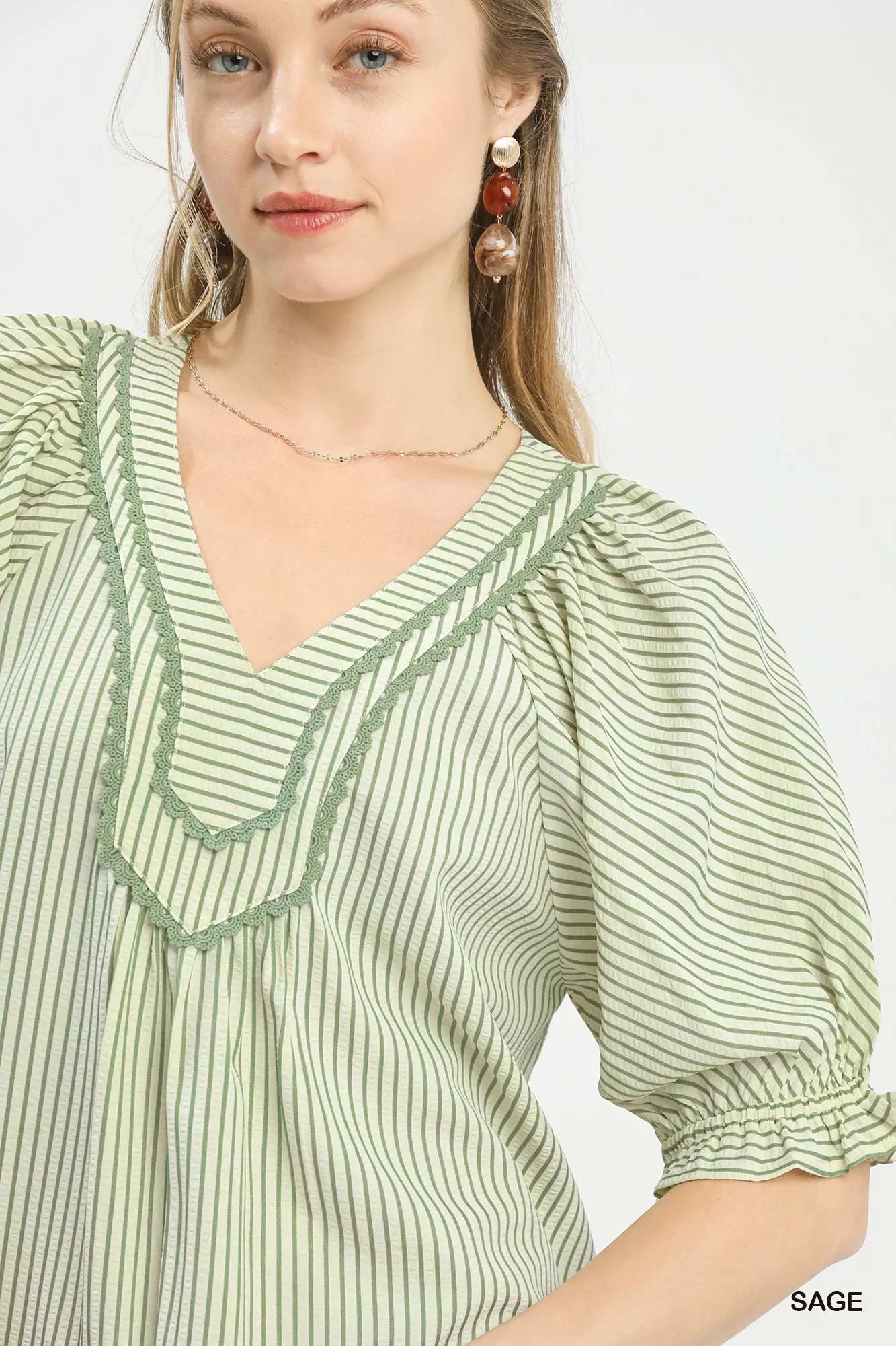 Close-up of sage striped v-neck blouse neckline at Blueberi Boutique