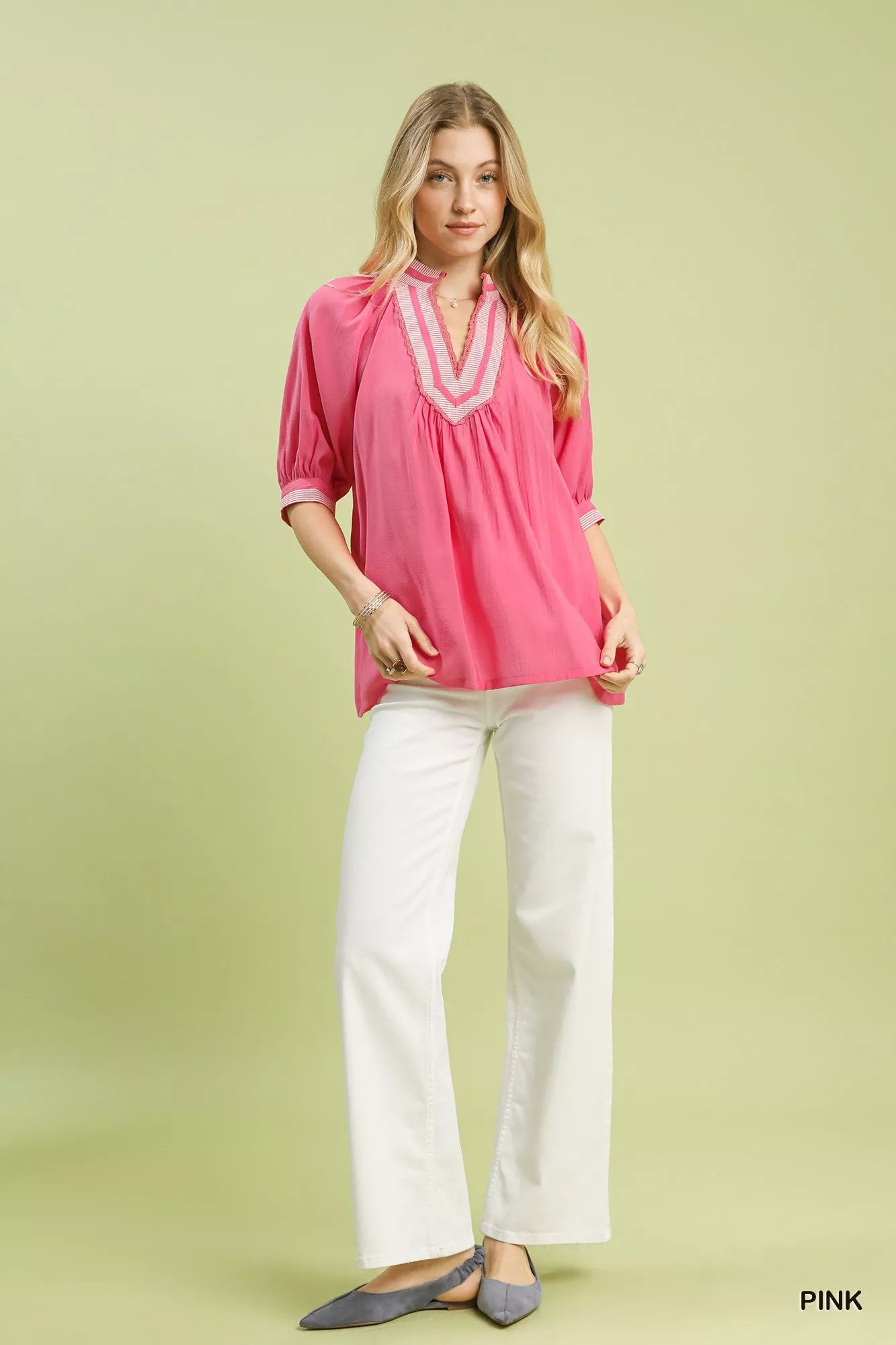Pink solid contrast trim pleated top on model with white pants at Blueberi Boutique