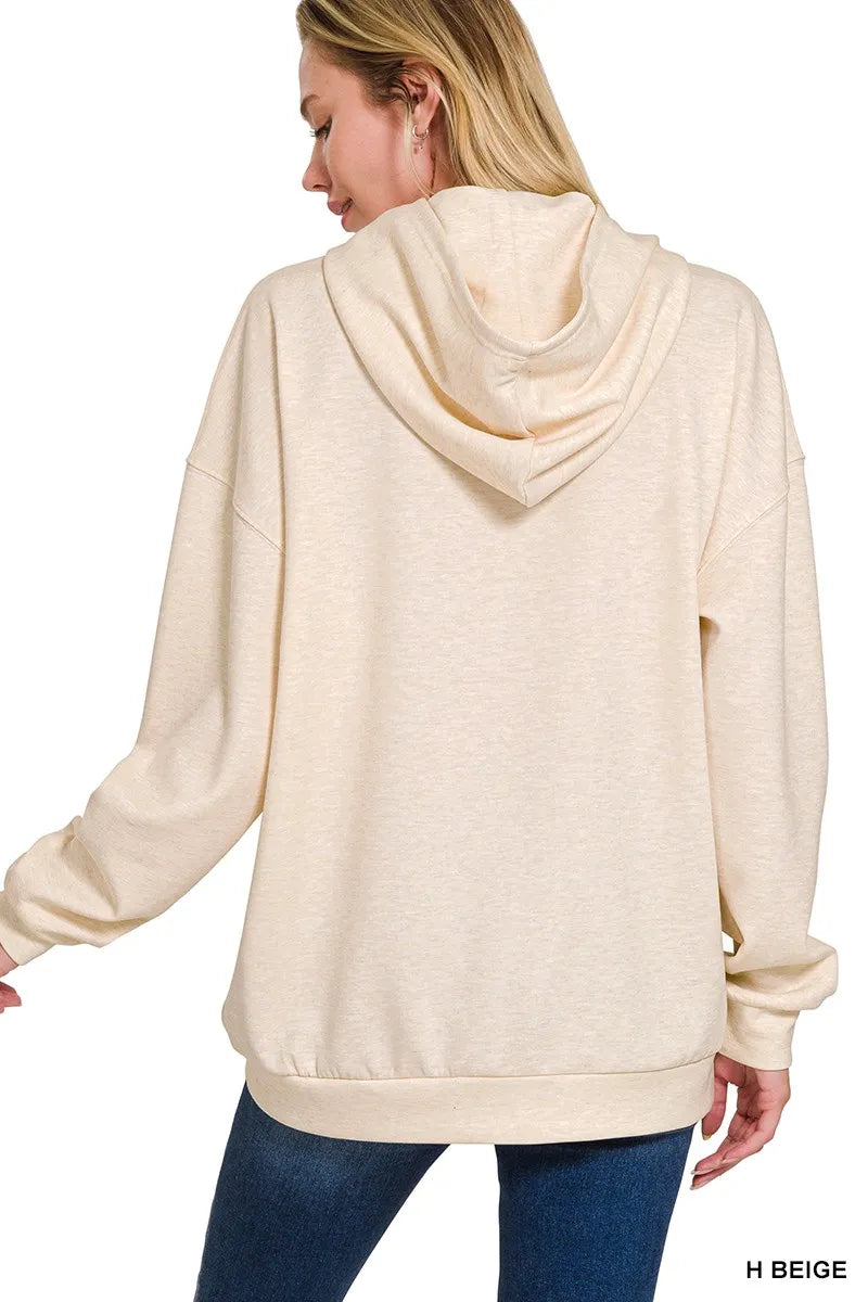 Woman wearing a beige hoodie from the back, with 'H Beige' label.