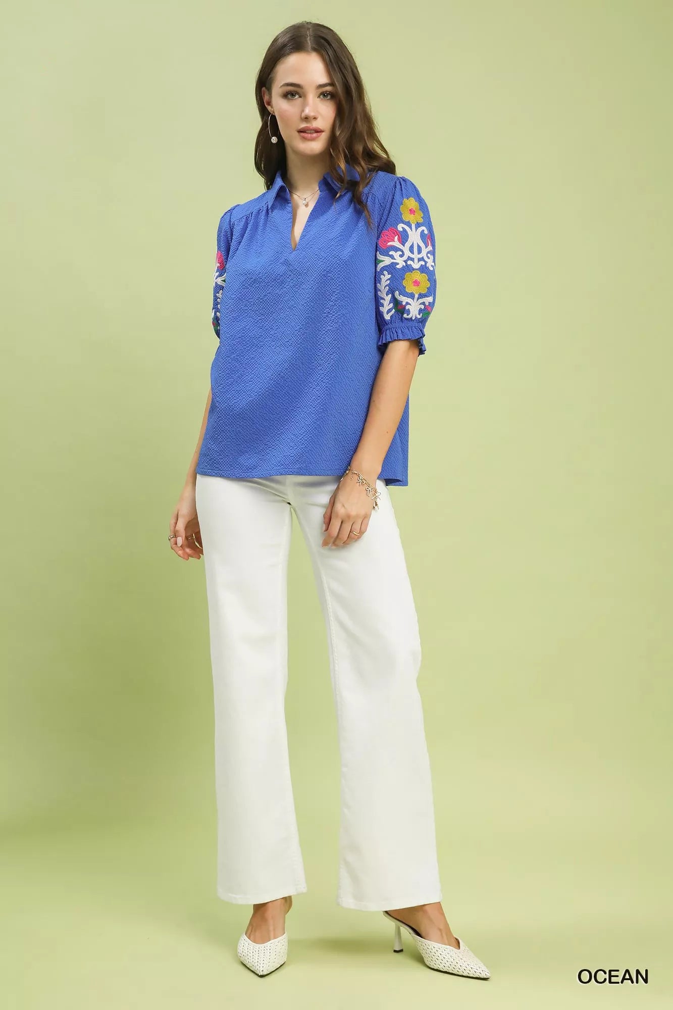 Model in blue seersucker embroidered sleeve blouse with white pants, polyester sizes S-L