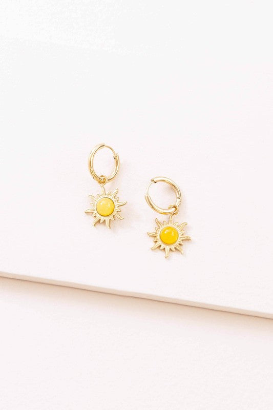 Pair of 14K gold hoop earrings with sunset charms (yellow sun centers) displayed on a white surface.