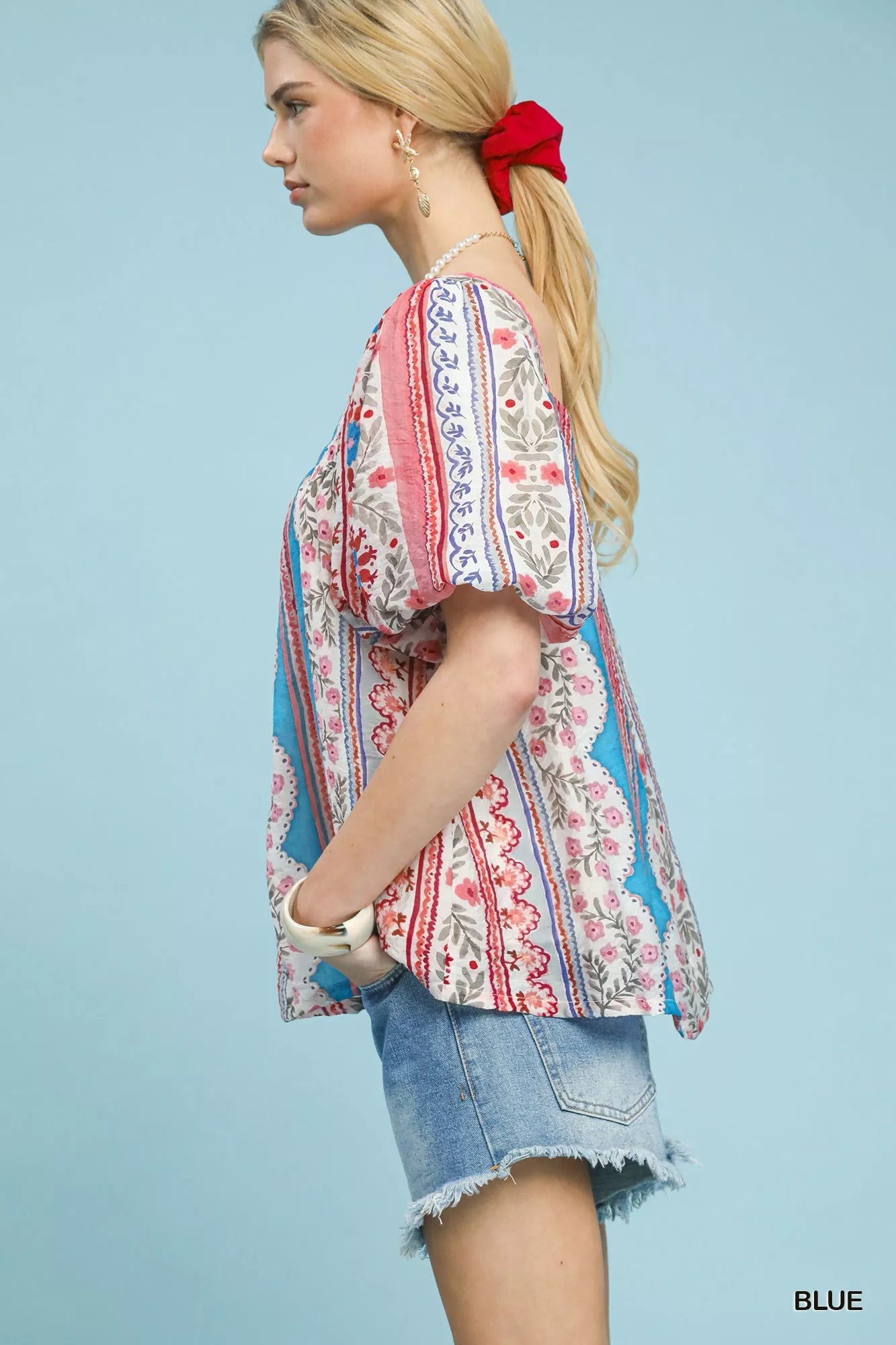 Side view of colorful patchwork puff sleeve blouse, denim shorts