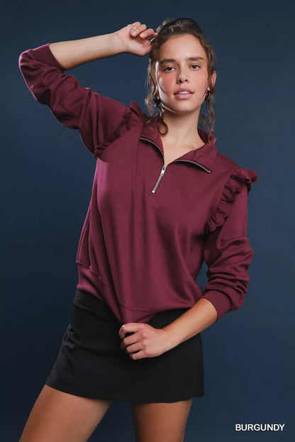 Burgundy quarter-zip sweatshirt with ruffled shoulders, black skirt