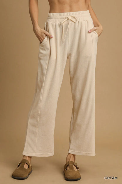 Woman wearing cream drawstring wide leg pants with pockets