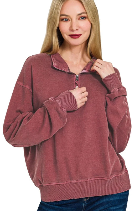 Woman wearing a maroon pullover with a zipper on a white background