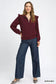 Burgundy ruffled quarter-zip sweatshirt with wide-leg jeans on model