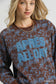 Close-up of Umgee scenic print cropped sweatshirt with "APRÈS ALL DAY" text detail at Blueberi Boutique