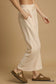 Side view of cream drawstring wide leg pants worn by woman
